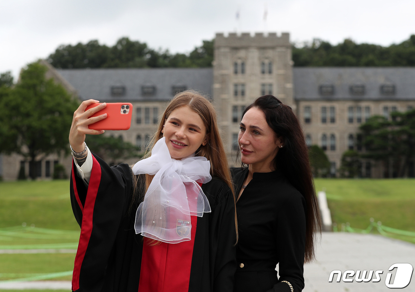 (서울=뉴스1) 박세연 기자 = 25일 서울 성북구 고려대학교에서 한 졸업생이 졸업가운을 입고 가족과 함께 기념사진을 찍고 있다.27일까지 하계 학위수여식을 갖는 고려대학교는 별도 …