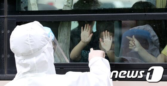 인천국제공항을 통해 입국한 아프간 인사 및 가족들이 27일 오전 임시 숙소로 지정된 경기도의 한 호텔에서 유전자증폭(PCR) 음성 판정을 받고 진천 공무원연수원으로 출발하고 있다. 경찰이 아프간 어린이와 창문을 사이에 두고 인사하고 있다. © News1 박지혜 기자