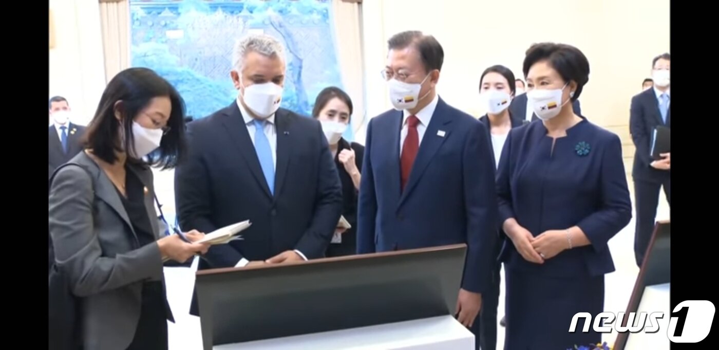 본문 이미지 - 문재인 대통령과 김정숙 여사가 이반 두케 콜롬비아 대통령의 발언을 통역으로 전해듣는 모습. (왼쪽부터) 김영주 국제회의통역사, 이홍주 행정안전부 사무관, 이은진 외교부 외무행정관. 청와대 유튜브 영상 갈무리. ⓒ 뉴스1