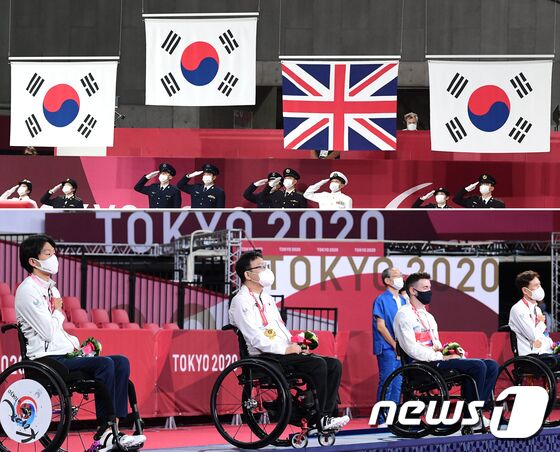 30일 일본 도쿄 메트로폴리탄체육관에서 열린 2020 도쿄패럴림픽 탁구 남자 개인전(TT1) 시상식에서 1~3위를 모두 차지한 한국 김현욱(은메달, 왼쪽부터), 주영대(금메달), 영국 매튜 토마스(동메달), 남기원(동메달)이 메달을 목에 걸고 국기가 게양되는 모습을 지켜보고 있다. 사진공동취재단