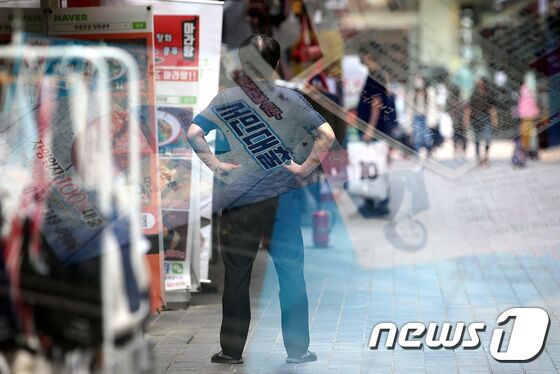 주요 은행의 대출중단에 이어 한도축소, 금리인상 움직임이 연쇄적으로 일어나면서 대출시장이 빠르게 얼어붙고 있다. 갑작스러운 대출제한 소식에 서민·실수요자들은 당혹감을 감추지 못하고 있다. 30일 오후 서울 명동거리에 한 상인이 거리를 바라보고 있다. 명동의 폐점 매장에 놓인 대부업체 광고지와 다중노출. 박지혜 기자