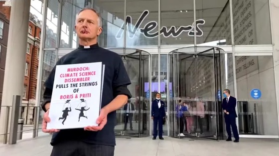 휴이스 신부는 입을 꿰맨 채 뉴스유케이 건물 정문 앞에서 푯말을 들고 시위했다. (CCA 유튜브 갈무리) © 뉴스1