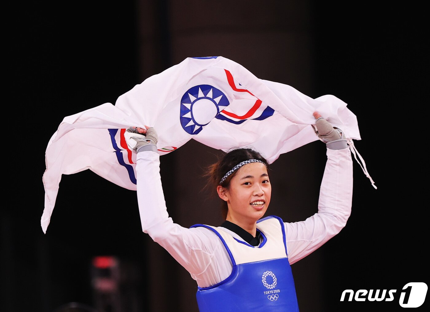 본문 이미지 - 대만의 태권도 선수가 동메달을 획득한 뒤 오륜기가 담긴 차이니스 타이베이 올림픽위원회기를 들어올리고 있다. ⓒ 로이터=뉴스1 ⓒ News1 정윤영 기자