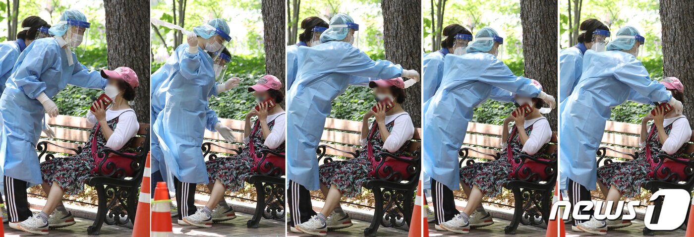 본문 이미지 - 폭염이 계속된 5일 오전 대구 중구 국채보상운동기념공원에 마련된 임시선별검사소에서 코로나19 진단검사를 기다리던 60대 여성이 어지러움을 호소하며 주저앉았다. 근처에 있던 의료진이 달려와 여성을 벤치로 안내한 뒤 얼음물을 목에 대고 자신이 착용한 얼음 스카프를 풀어 여성에게 채워주고 있다. 이 여성은 한사코 구급차 호출을 거부해 의료진의 안내를 받아 코로나19 검사를 마친 뒤 근처 있던 보호자와 연락이 닿아 함께 병원으로 향했다. ⓒ News1 공정식 기자
