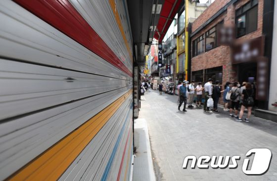 서울 명동거리에 폐업한 가게 앞 음식점에 손님들이 줄을 서 있다. 2021.8.8/뉴스1 © News1 이성철 기자