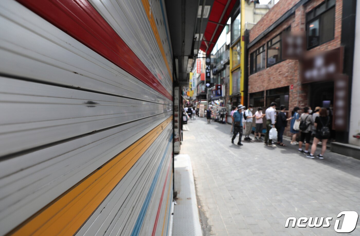 본문 이미지 - 서울 명동거리에 폐업한 가게 앞 음식점에 손님들이 줄을 서 있다. 2021.8.8/뉴스1 ⓒ News1 이성철 기자
