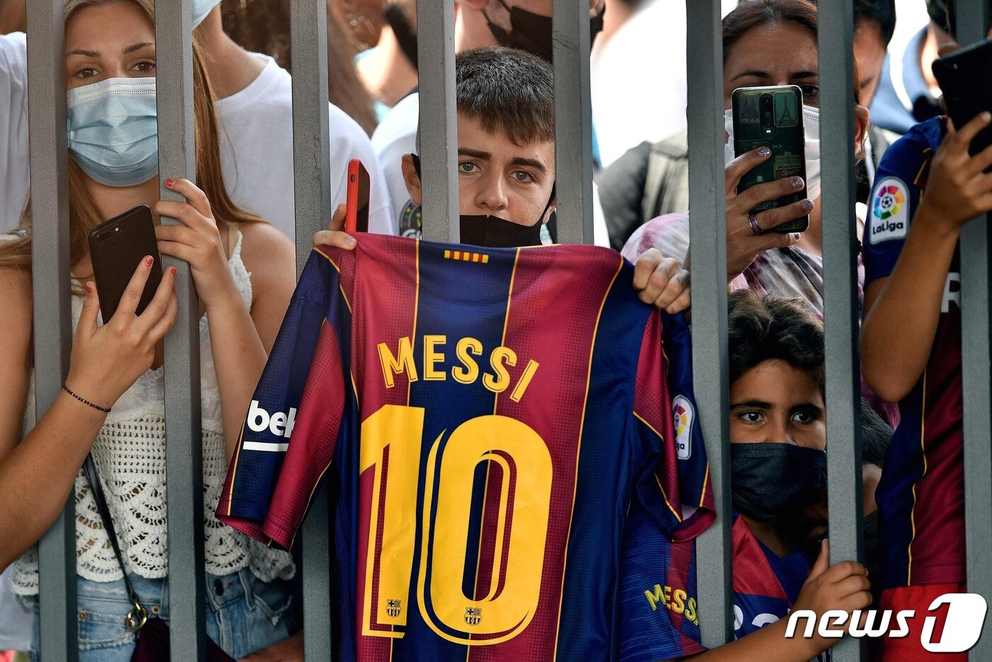본문 이미지 - 리오넬 메시의 팬들이 8일 이적을 발표하는 기자회견장에서 그의 유니폼을 들어보이며 애석해 하고 있다. ⓒ AFP=뉴스1 ⓒ News1 박형기 기자
