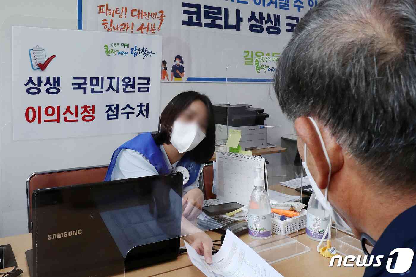 10일 오전 서울 성북구 길음1동 주민센터에 마련된 코로나 상생 국민지원금 상담 창구에서 한 시민이 이의신청 접수를 하고 있다. 홍남기 경제부총리는 지난 8일 코로나 상생 국민지원금 지급에 따른 국민의 이의신청이 폭주하고 있다는 지적에 대해