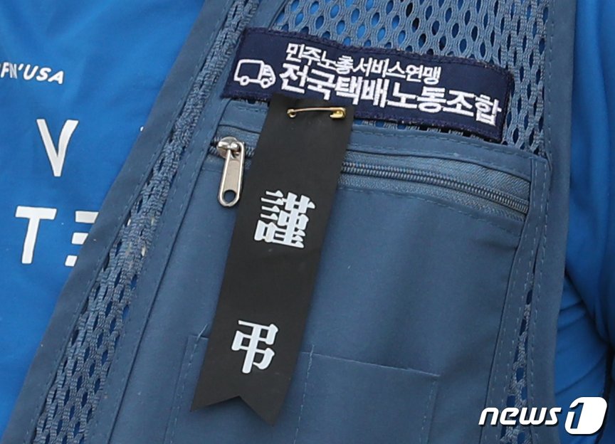 본문 이미지 - 10일 오전 서울 용산구 로젠택배 본사에서 전국택배노동조합 주최로 열린 로젠택배 부산 사하지점 직장폐쇄 문제 해결 촉구 기자회견에서 노조원들의 옷에 '근조' 리본이 달려 있다. 이날 기자회견에서 참석자들은 "직장폐쇄를 강행한 로젠택배 사하지점을 규탄한다＂며 로젠택배 본사에 문제 해결을 촉구했다. 송원영 기자