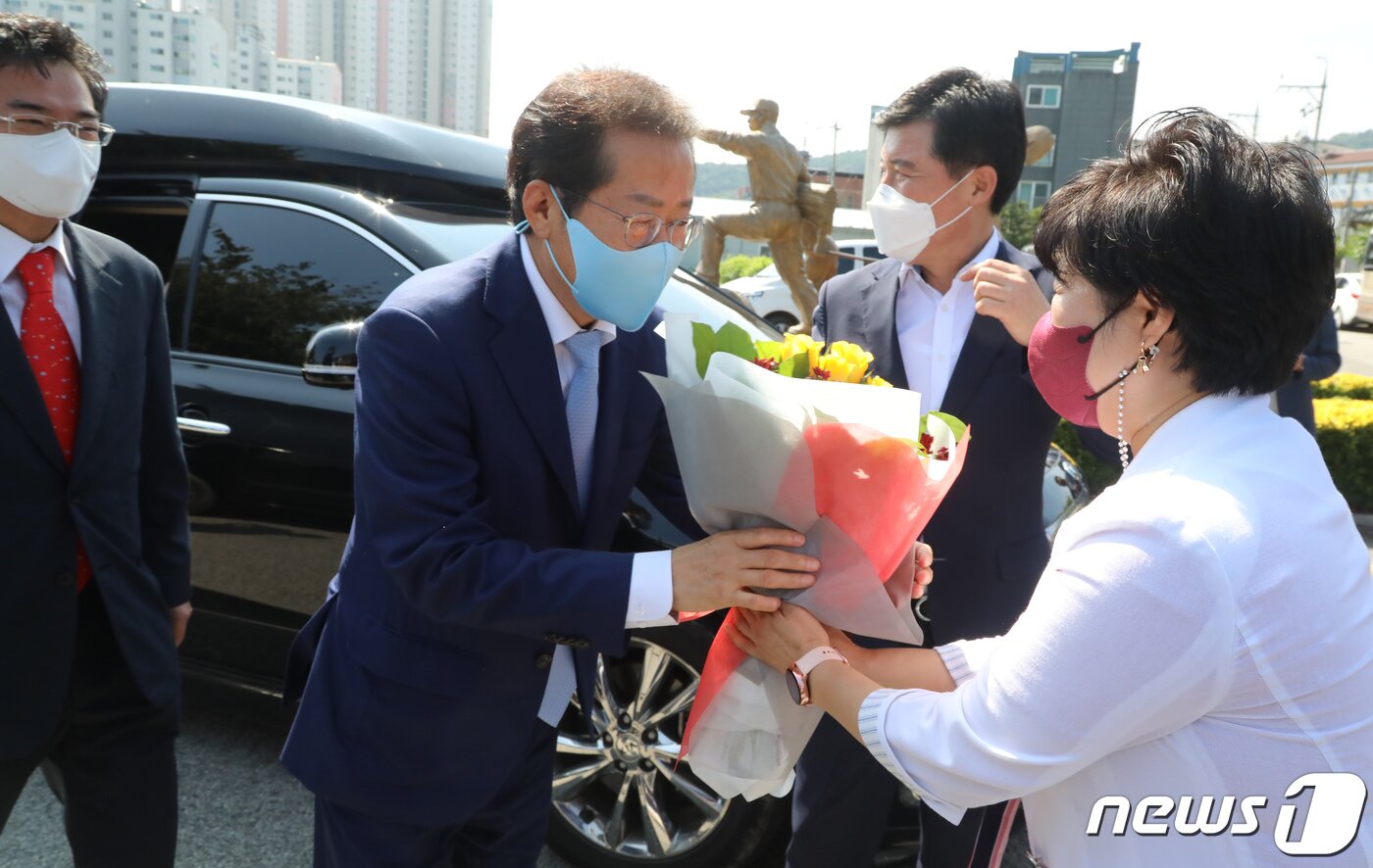 본문 이미지 - 12일 경북 구미 박정희 생가를 방문한 홍준표 국민의힘 대선 예비후보가 장미경 구미시의원으로부터 환영꽃다발을 받고 있다. 홍 후보는 &#34;민주당이 우리당을 공범으로 엮으려고 짜고 있는 프레임에 넘어가면 바보같은 짓＂이라고 경계했다.2021.9.12/뉴스1 ⓒ News1 정우용 기자