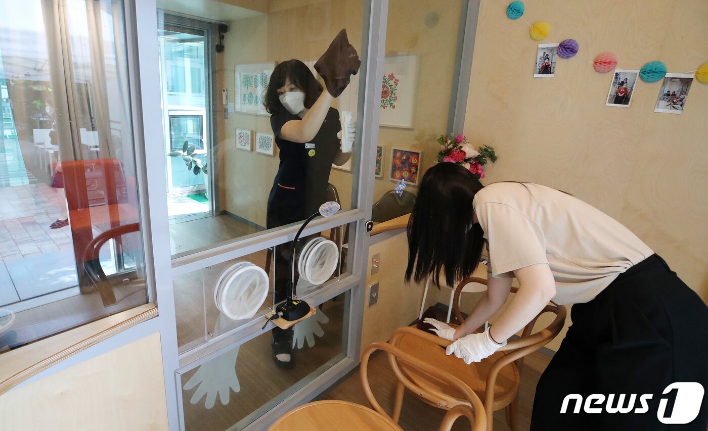 본문 이미지 - 추석 연휴를 포함해 2주간 요양병원과 요양시설 방문 면회가 허용된 13일 오후 서울 성동구 시립동부노인요양센터에 설치된 면회전용공간 '가족의 거실'에서 센터 관계자들이 방역작업을 하고 있다. 정부는 13일부터 추석 연휴를 포함해 2주간 요양병원과 요양시설 방문 면회가 허용한다고 밝혔다. 단, 접촉 면회는 환자·입소자와 면회객 모두 예방접종 완료 14일이 지났을 경우에만 가능하다. 2021.9.13/뉴스1 ⓒ News1 김진환 기자