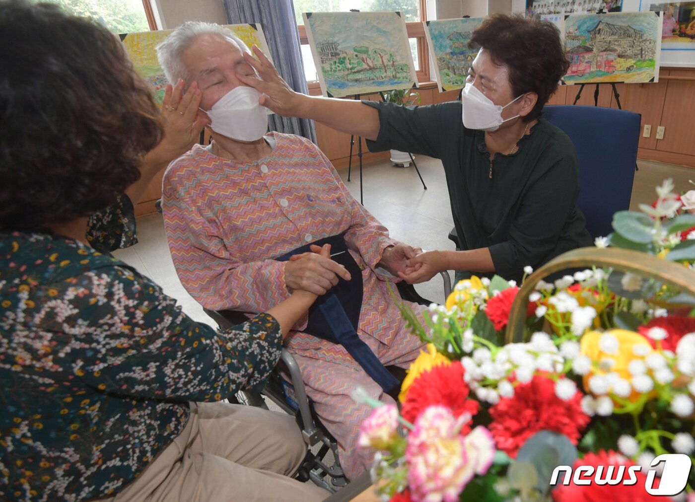 본문 이미지 - 추석 연휴를 일주일여 앞둔 13일 오후 경기도 수원시 장안구 수원보훈요양원 면회실에서 입소자인 아버지 이주환 씨(93)를 면회 온 딸 이순복 씨(70)와 이순애 씨(63)가 손을 맞잡고 이야기를 나누고 있다. 방역당국은 사회적 거리두기 단계와 상관없이 9월 13부터 26일까지 2주간 요양병원·요양시설 방문 면회를 허용하고, 면회객 분산을 위해 사전예약제를 받는 '추석 특별방역대책'을 시행한다. 2021.9.13/뉴스1 ⓒ News1 김영운 기자