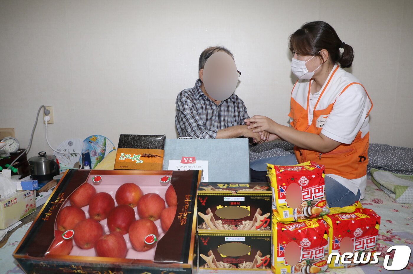 본문 이미지 - 지난 16일 오후 광주 서구 광천동 한 가정에서 이은숙 월드비전 무진종합사회복지관 과장이 독거노인에게 명절 선물 꾸러미를 전달하고 있다. 2021.9.18/뉴스1