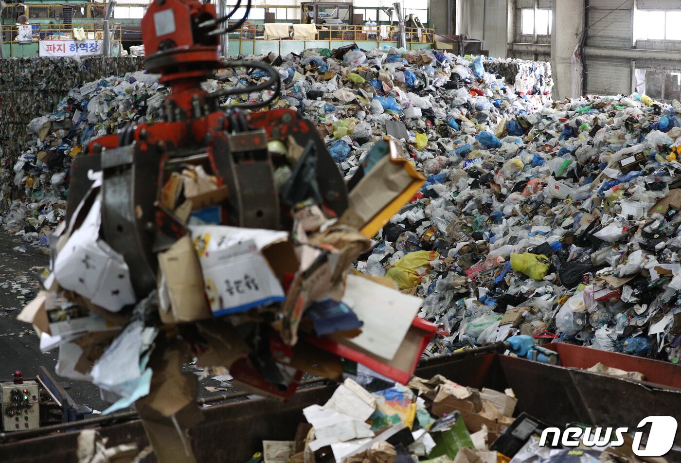 본문 이미지 - 추석 명절 연휴가 끝난 23일 서울 송파구 송파자원순환공원에서 관계자들이 재활용쓰레기 선별장에 쌓인 쓰레기를 포크레인을 이용해 분류하고 있다. 2021.9.23/뉴스1 ⓒ News1 신웅수 기자
