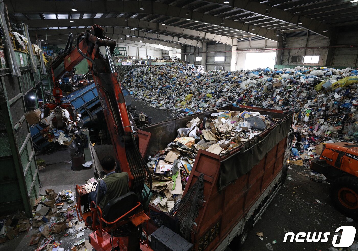본문 이미지 - 추석 명절 연휴가 끝난 23일 서울 송파구 송파자원순환공원에서 관계자들이 재활용쓰레기 선별장에 쌓인 쓰레기를 분류하고 있다. 2021.9.23/뉴스1 ⓒ News1 신웅수 기자