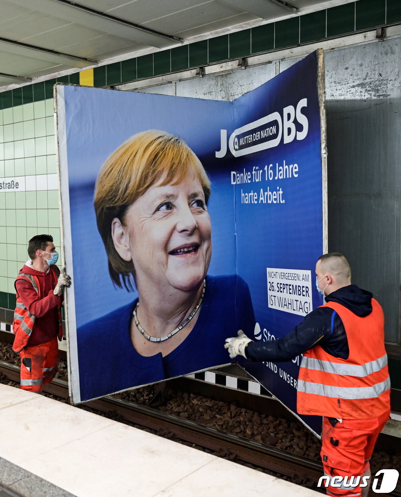 본문 이미지 - 24일(현지시간) 노동자들이 총선을 앞두고 ‘국가의 어머니-16년간 열심히 일한 것에 감사한다’가 적힌 앙겔라 메르켈 독일 총리의 광고를 철거하고 있다. 독일은 16년 만에 총리 교체를 앞두고 있다. ⓒ 로이터=뉴스1 ⓒ News1 금준혁 기자