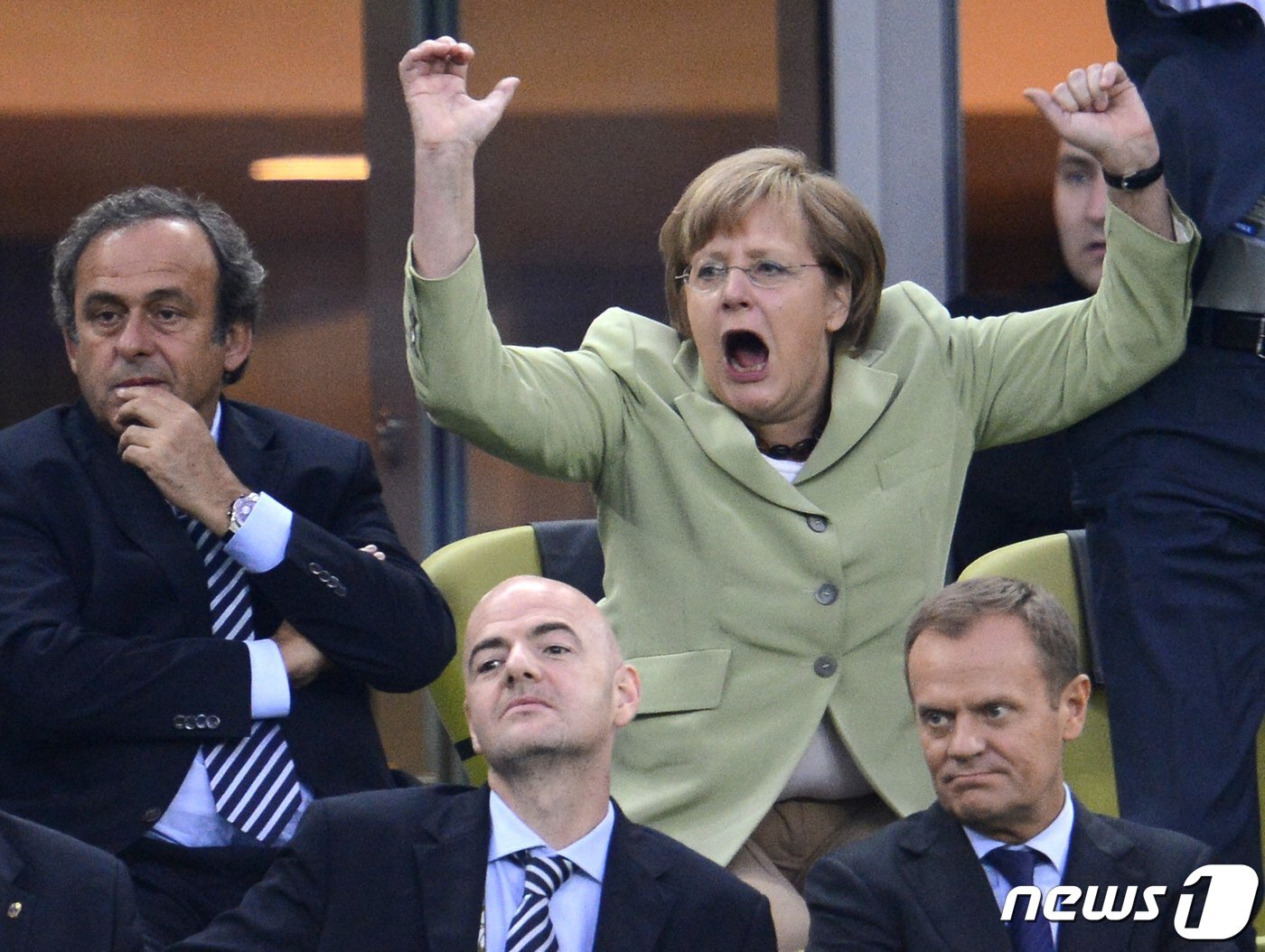 본문 이미지 - 유로 2012 축구 챔피언십 독일과 그리스 결승전에서 필립 람 선수가 그리스를 상대로 점수를 내자 관중석에서 이를 지켜보던 앙겔라 메르켈 독일 총리가 환호하는 모습. ⓒ AFP=뉴스1 ⓒ News1 최서윤 기자