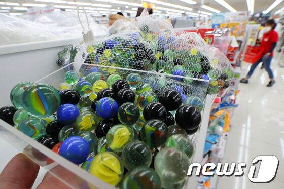 넷플릭스 오리지널 시리즈 '오징어게임'이 세계적인 인기를 끌며 드라마에 등장하는 소품도 인기를 끌고 있다. 드라마 인기와 함께 추억을 자극하는 요소가 더해져 구슬치기 등의 판매가 대폭 늘었다. 28일 온라인 마켓플레이스 옥션에 따르면 오징어게임 방송 이후 지난 17일부터 26일까지 구슬치기 매출은 직전월 동기간(8월17~8월26일) 대비 275% 증가 한 것으로 나타났다. 28일 서울의 한 생활용품 전문점에서 구슬치기용 구슬이 판매되고 있다. 민경석 기자