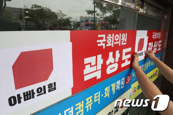 29일 오전 대구경북대학생진보연합 회원들이 아들의 퇴직금 50억원 논란으로 국민의힘을 탈당한 대구 남구 곽상도 의원 지역구 사무실 앞에서 국회의원 사퇴요구 기자회견을 마친 뒤 국민의힘 당 로고 위에 '아빠의힘'이라고 쓰여진 로고를 붙이고 있다. 공정식 기자