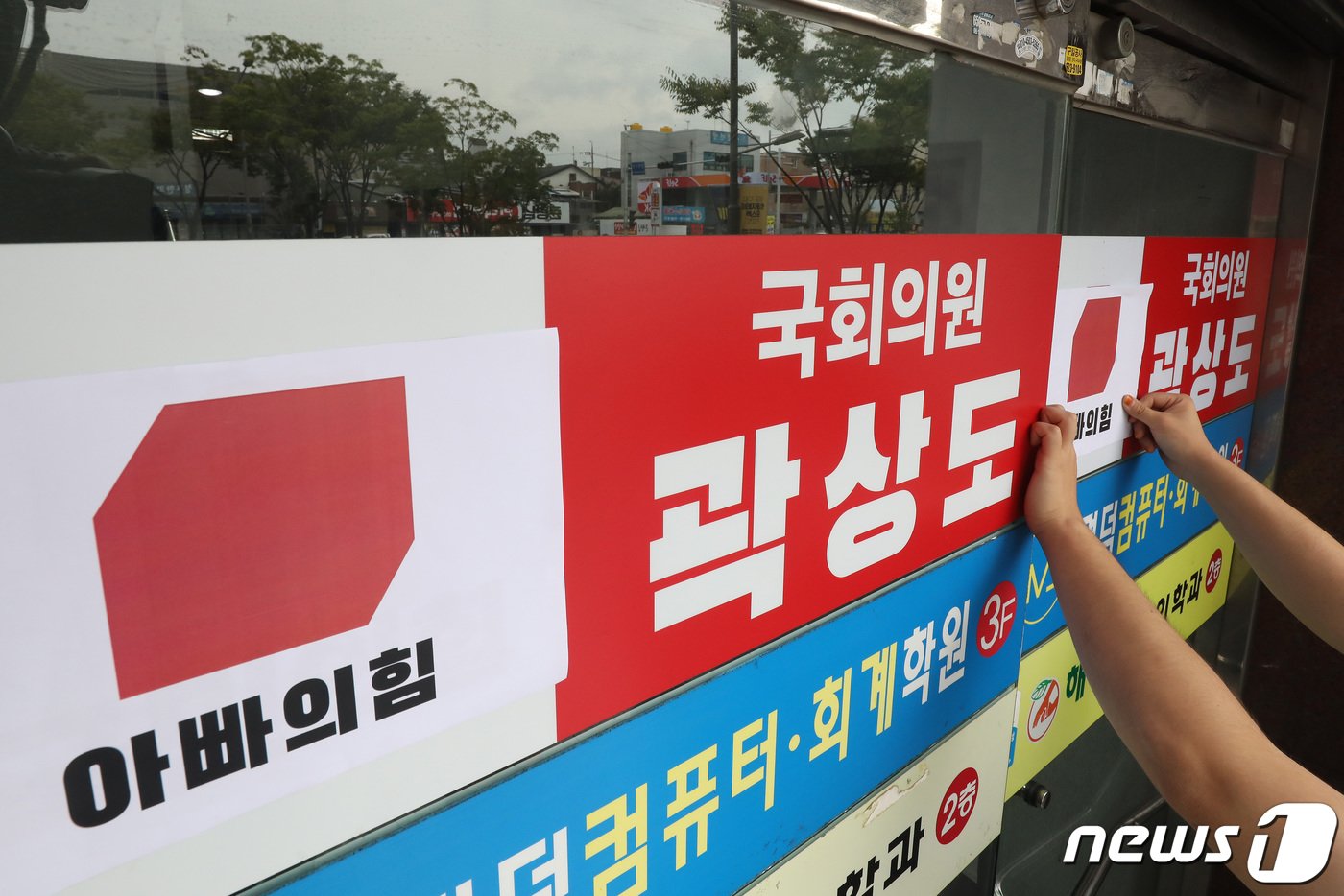 본문 이미지 - 29일 오전 대구경북대학생진보연합 회원들이 아들의 퇴직금 50억원 논란으로 국민의힘을 탈당한 대구 남구 곽상도 의원 지역구 사무실 앞에서 국회의원 사퇴요구 기자회견을 마친 뒤 국민의힘 당 로고 위에 '아빠의힘'이라고 쓰여진 로고를 붙이고 있다.  공정식 기자