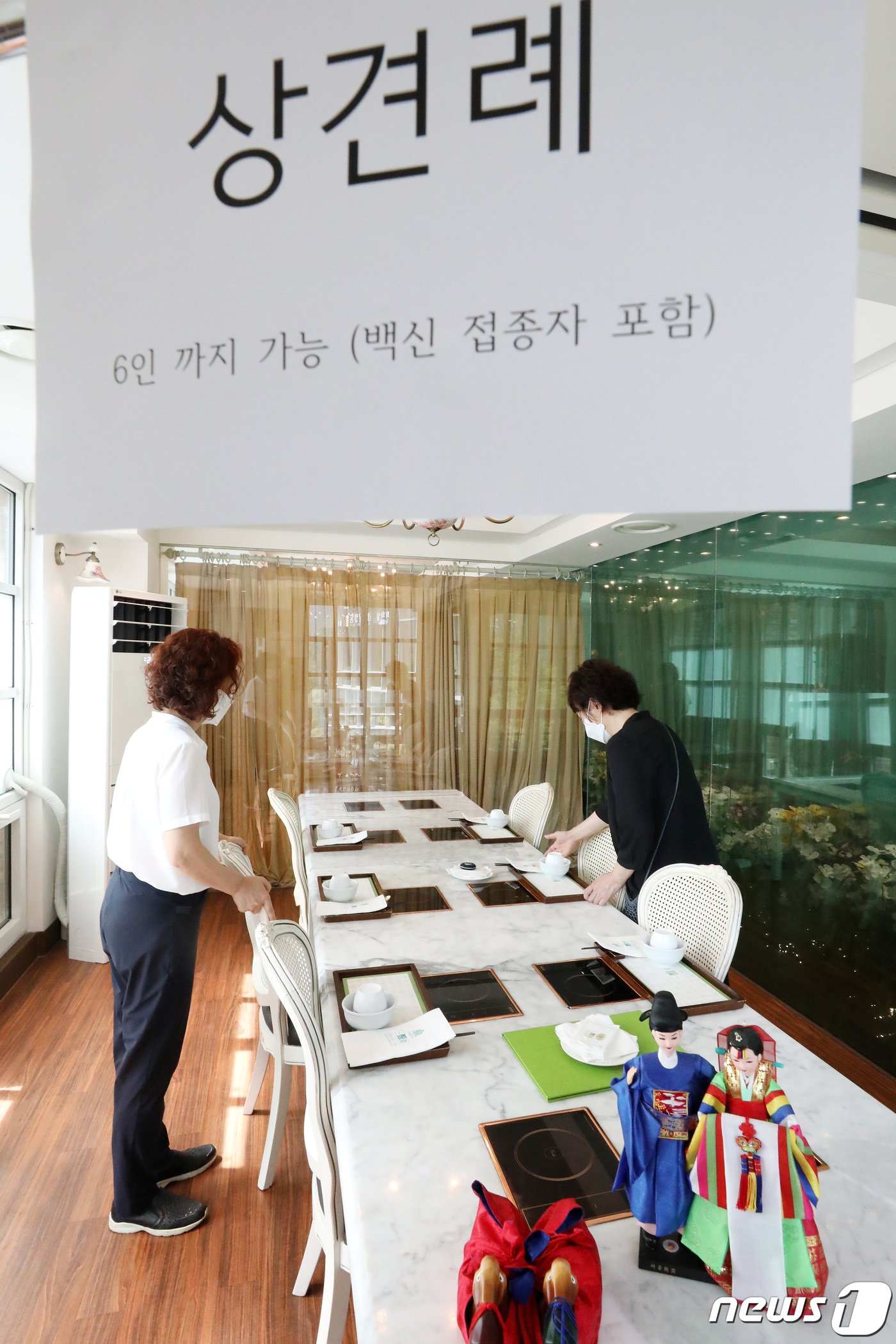 본문 이미지 - 사회적 거리두기 조정안 도입을 하루 앞둔 5일 오후 서울 종로구 일품당 프리미엄에서 직원들이 6인 손님맞이를 준비하고 있다.  조태형 기자