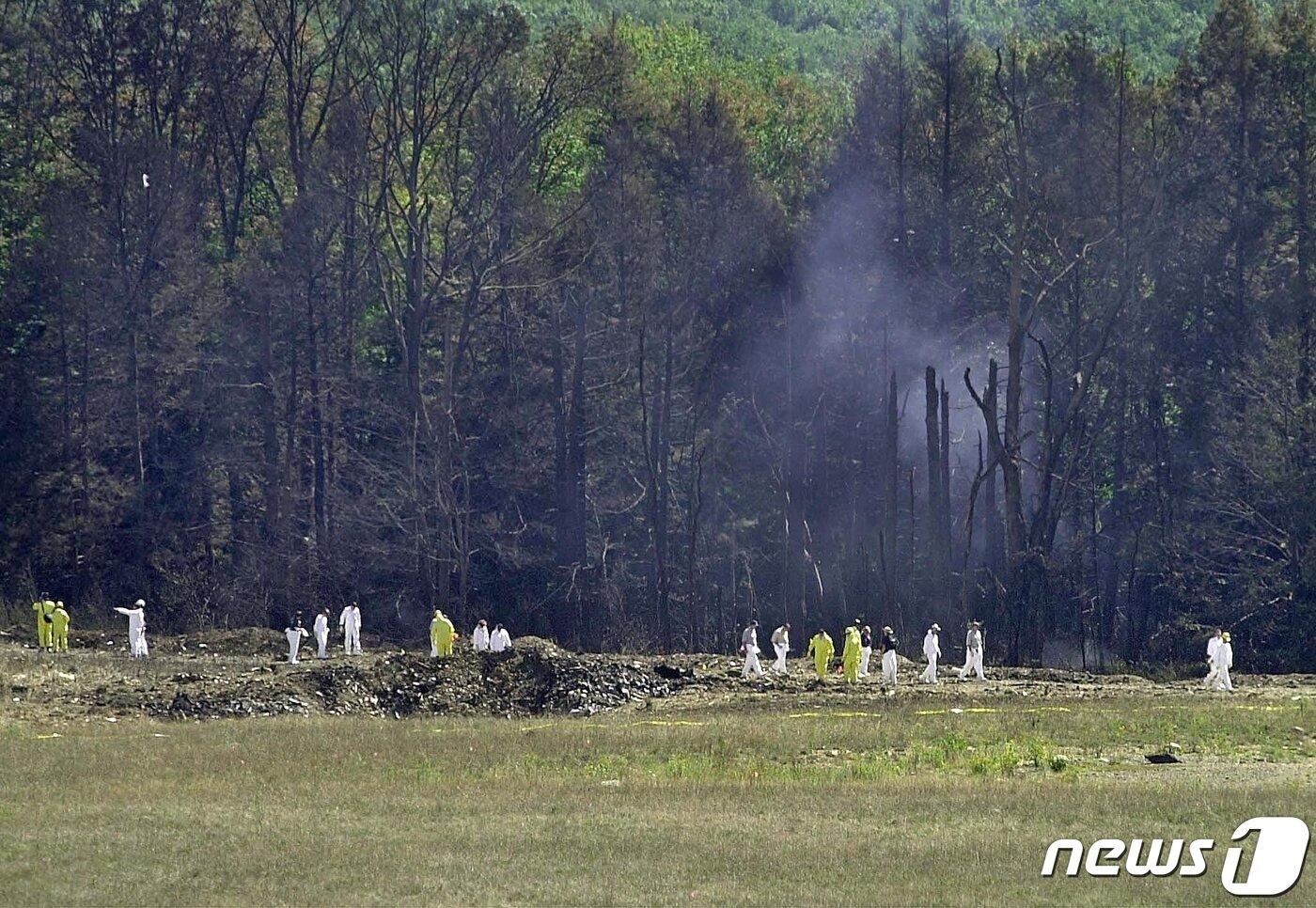 본문 이미지 - 수사관들이 미국 펜실베니아주 한 광산에 추락한 유나이티드항공 93편 일대를 살피고 있다. 2001.09.11 ⓒ AFP=뉴스1