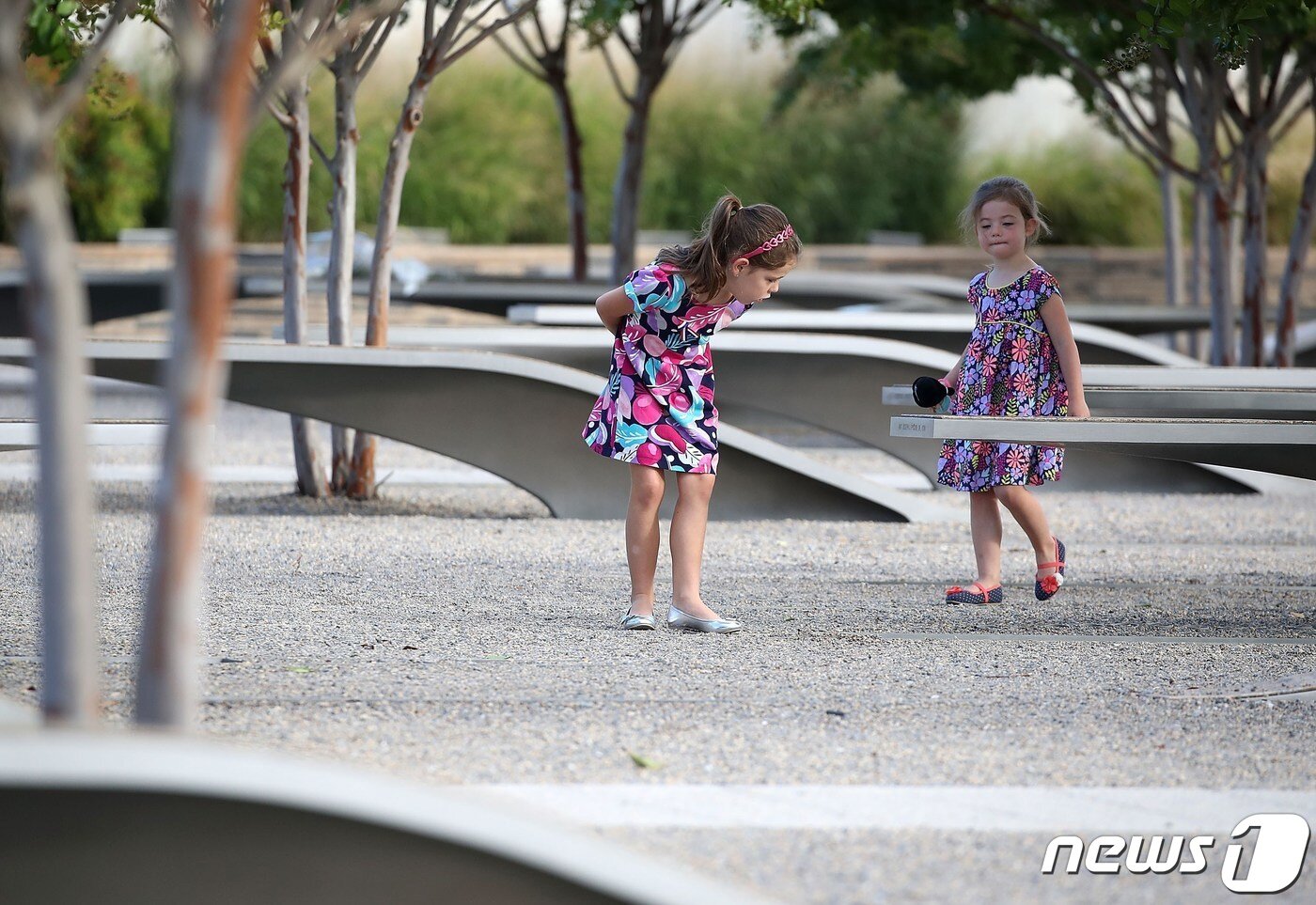 본문 이미지 - 두 소녀가 앨링턴 소재 국방부 청사 펜타곤 주변에 마련된 911 추모 공원을 걷고 있다. 2016.09.11 ⓒ AFP=뉴스1