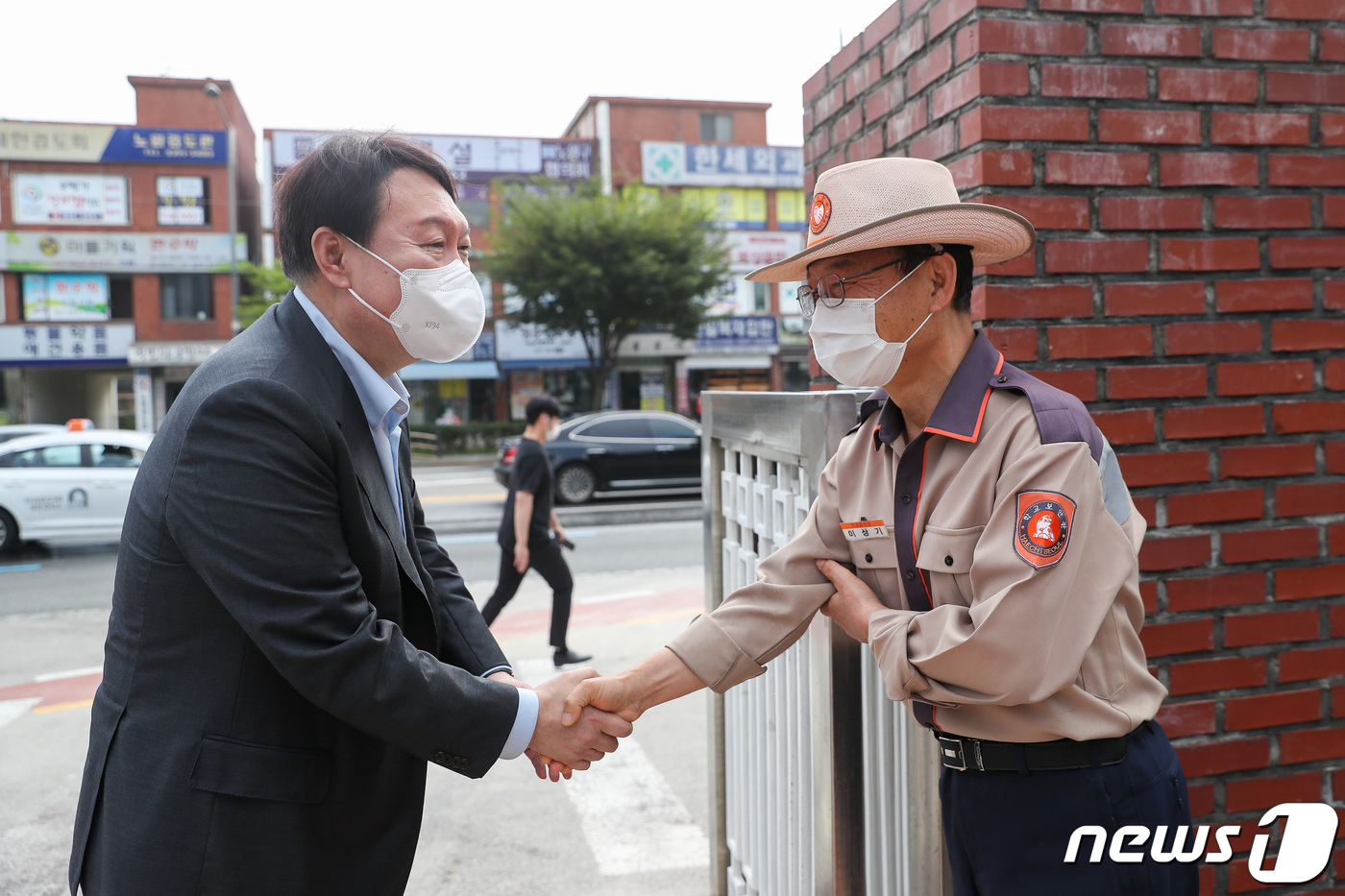 (서울=뉴스1) 이동해 기자 = 국민의힘 대권 주자인 윤석열 전 검찰총장이 9일 오전 서울 노원구 노일초등학교 인근에서 교통 안내 봉사에 앞서 학교보안관과 인사를 나누고 있다.윤 …