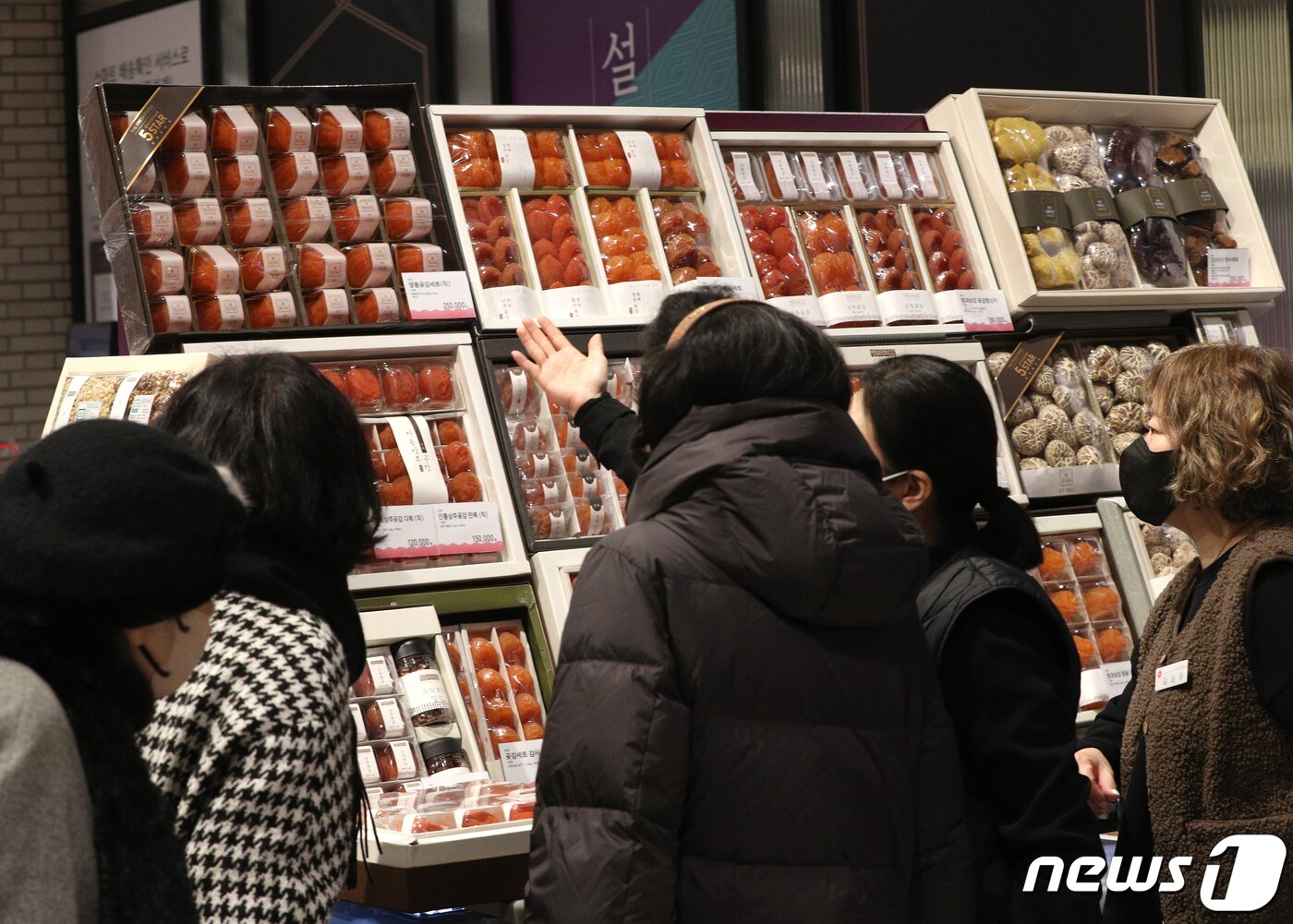 본문 이미지 - 21일 오후 서울의 한 백화점에서 시민들이 설 선물세트를 고르고 있다. 신종 코로나바이러스 감염증(코로나19) 여파로 올해 설에도 고향을 방문하는 대신 프리미엄 선물을 보내는 사람이 늘어날 것으로 전망된다. 특히 이번 설 명절부터 부정청탁금지법의 농수축산물 선물가액 범위가 10만원에서 20만원으로 상향 조정되면서 10만~20만원 금액대를 형성하는 선물세트가 인기를 끌고 있다. 백화점 업계도 설 선물세트 매출액이 역대 최고치를 기록하면서 가성비 대신 프리미엄 선물 세트 판매에 주력하고 있다. 2022.1.21/뉴스1 ⓒ News1 신웅수 기자