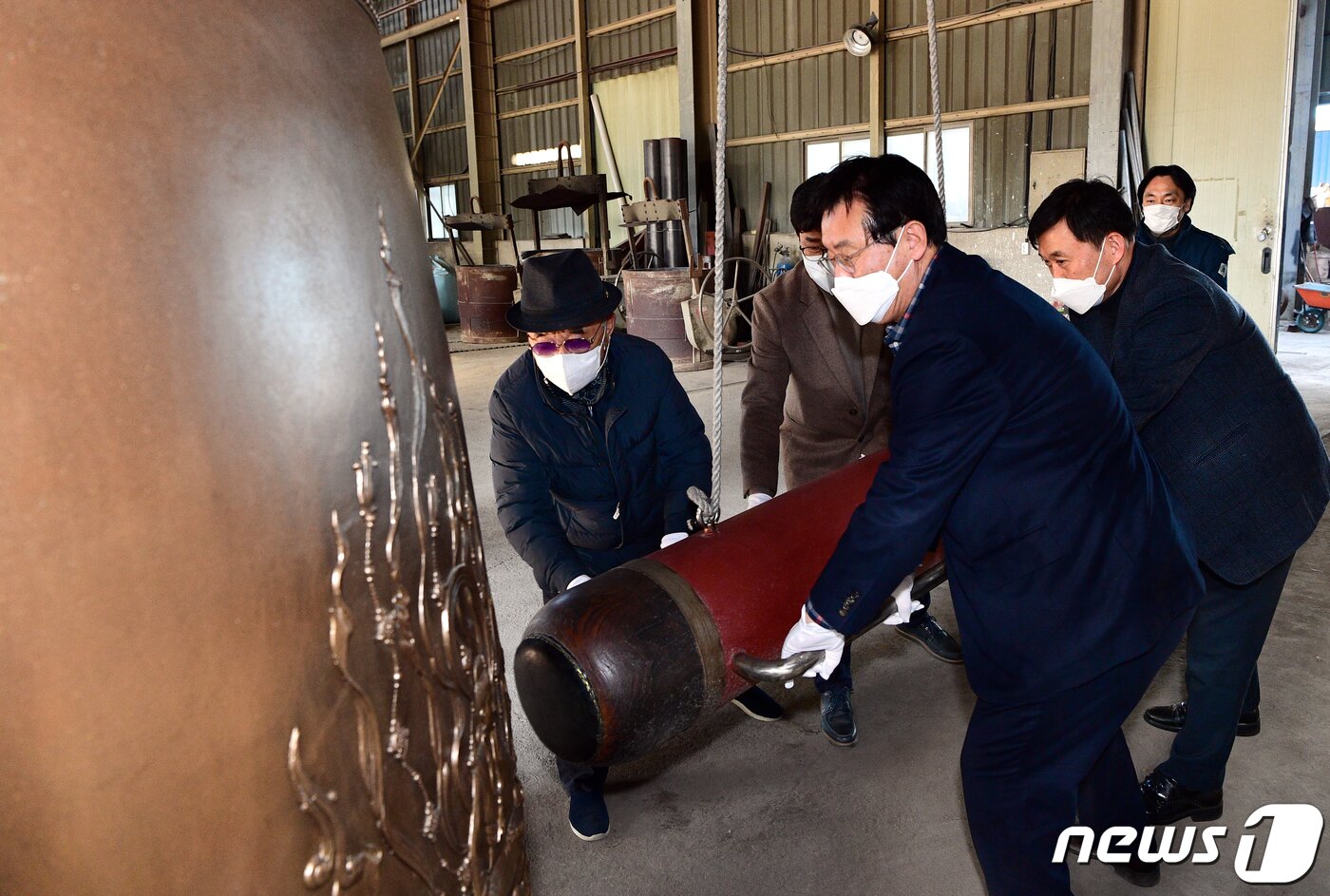 본문 이미지 - 곽용환 고령군수(오른쪽 앞줄 첫번째)가 21일 충북 진천 성종사에서 대가야 대종을 타종하고 있다. 무게 2022관(7.58톤), 높이 2.8m, 지름 1.6m의 대종 표면은 대가야 고령의 대표 유적과 출토유물, 군조, 대가야 건국신화의 정견모주 등을 문양화했다. (고령군 제공) /뉴스1 ⓒ News1 정우용 기자
