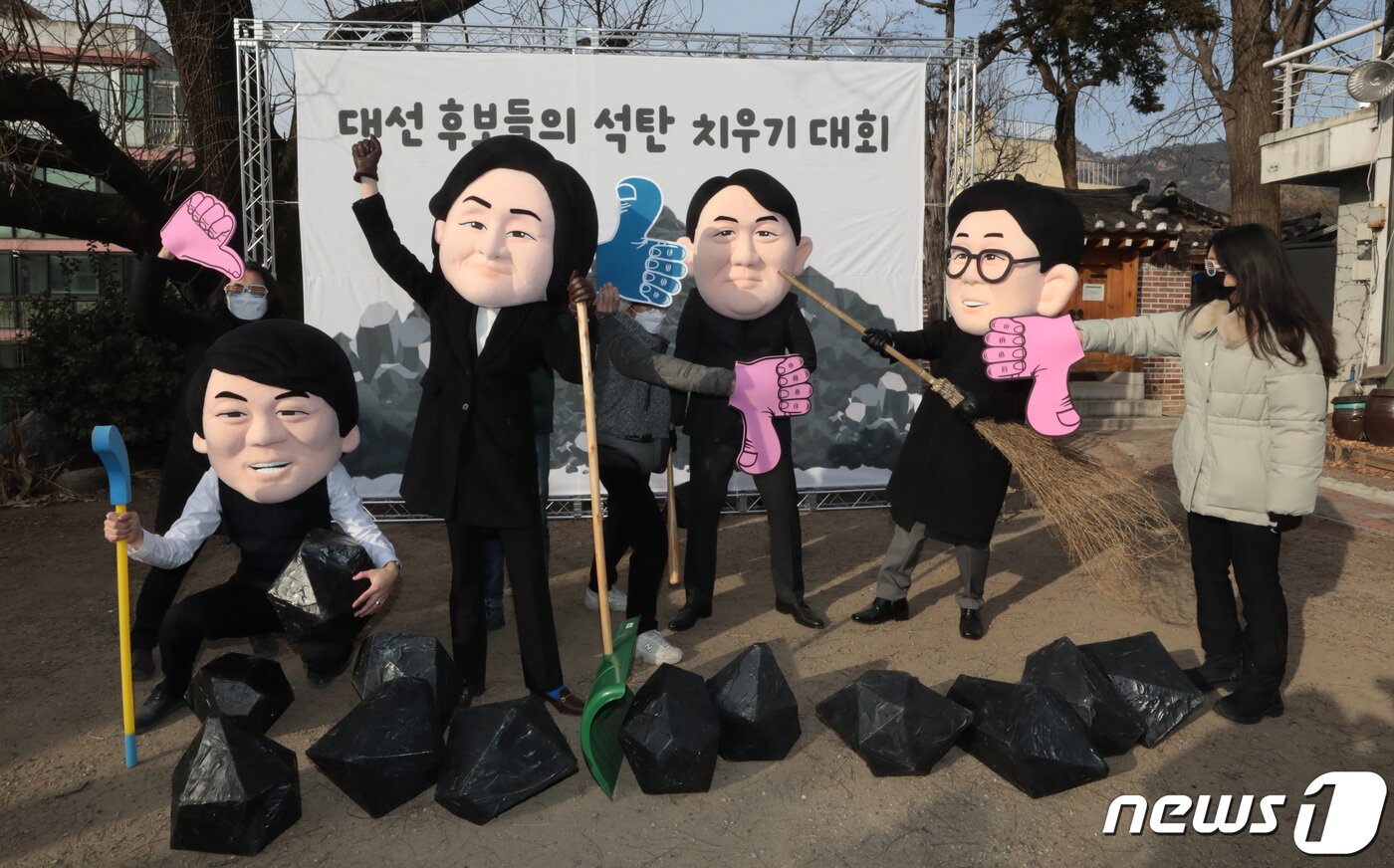 본문 이미지 - 5일 서울 종로구 환경운동연합 회화나무 마당에서 열린 '대선 후보들의 석탄 치우기 대회'에서 각 정당의 대선후보들의 탈을 쓴 탈석탄 연대 '석탄을 넘어서' 관계자들이 행사를 진행하고 있다. 2022.1.5/뉴스1 ⓒ News1 이성철 기자