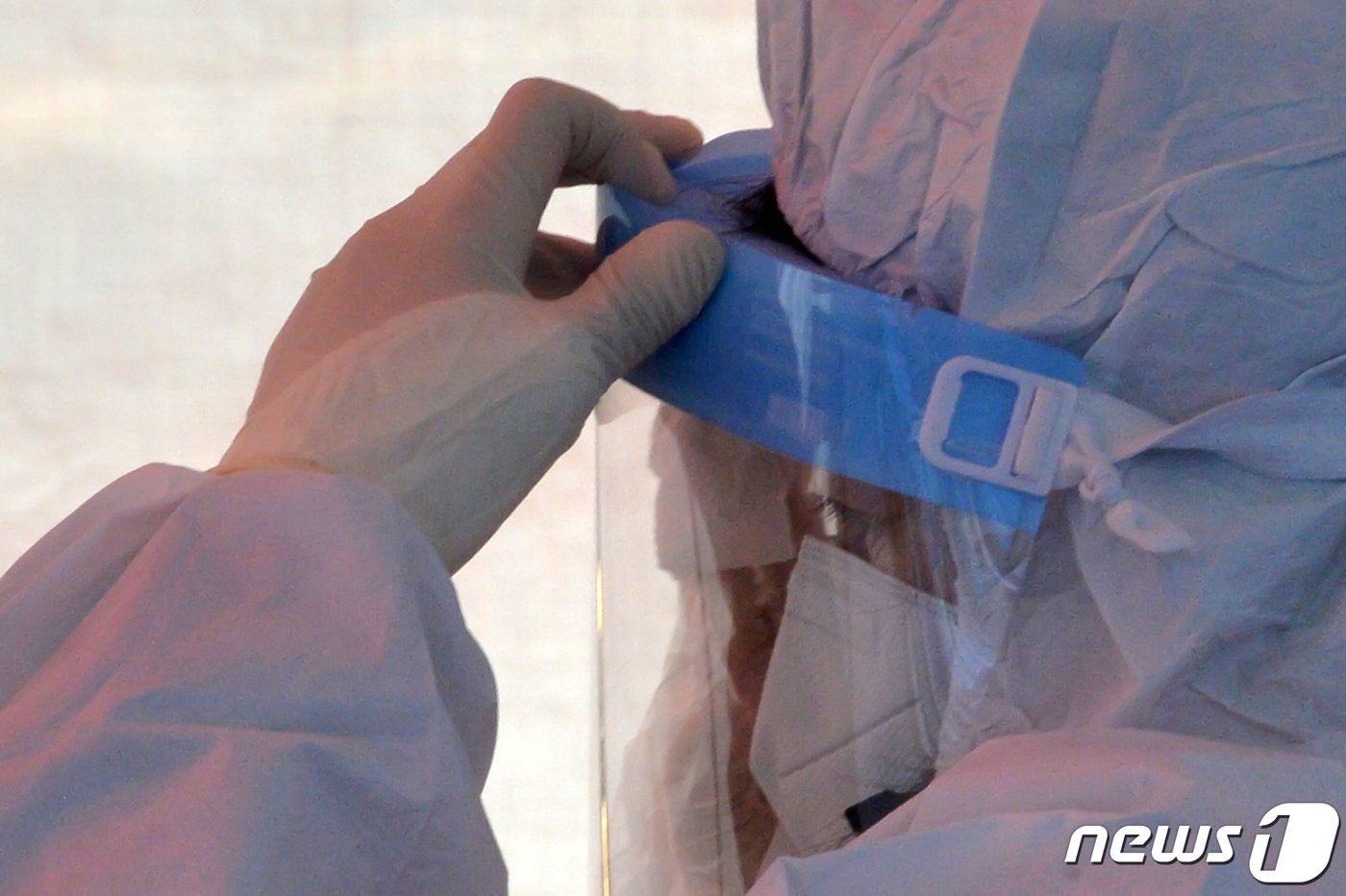 본문 이미지 - 2022년 1월, 경북 포항시 북구 죽도시장에 설치된 신종코로나바이러스 감염증(코로나19)선별진료소에서 의료진이 땀을 닦고 있다. 2022.1.6/뉴스1 ⓒ News1 최창호 기자