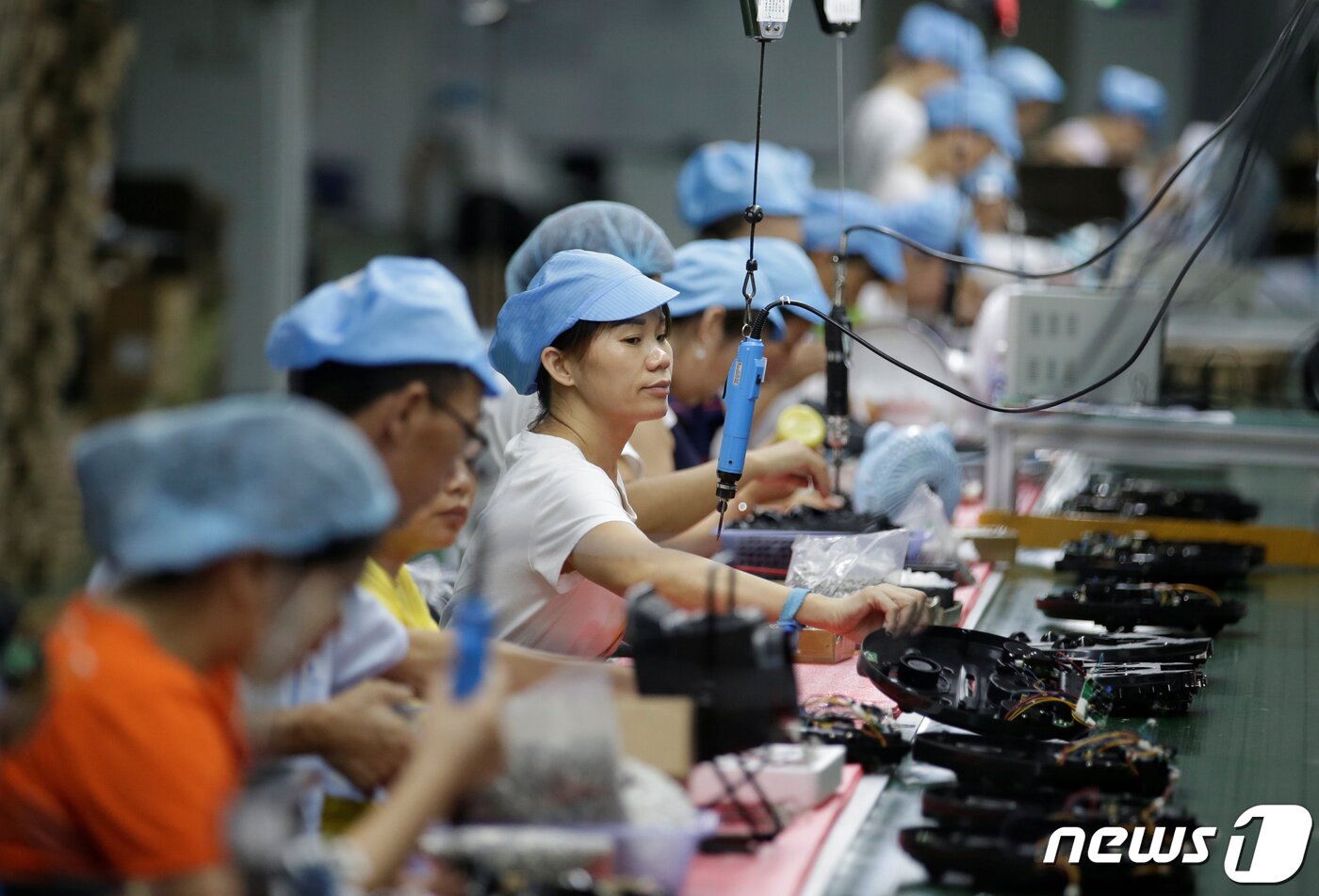 본문 이미지 - 2019년 8월9일(현지시간) 중국 선전 '마츠텍' 공장에서 노동자들이 로봇청소기 생산라인에서 일하고 있다. 2022.01.06/news1 ⓒ 로이터=뉴스1 ⓒ News1 김민수 기자