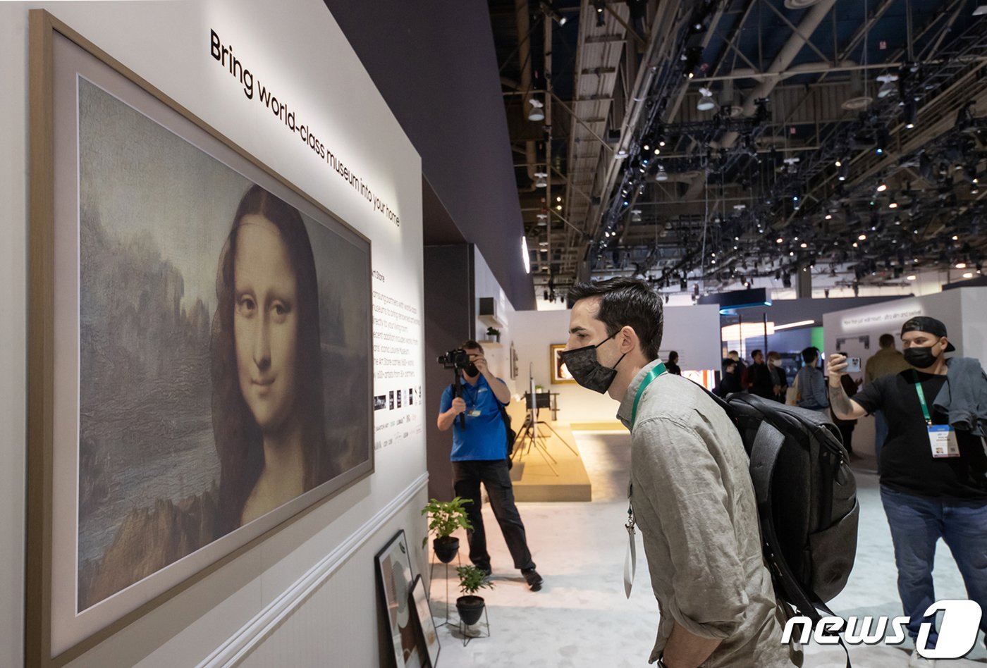 본문 이미지 - 세계 최대 가전·IT 전시회 CES2023이 5일(현지시간) 미국 네바다주 라스베이거스에서 개막해 나흘간 열린다. 사진은 지난해 열린 'CES 2022'에서 삼성전자 전시관을 찾은 관람객들이 '더 프레임' TV를 체험하고 있는 모습. (삼성전자 제공) 2022.1.7/뉴스1