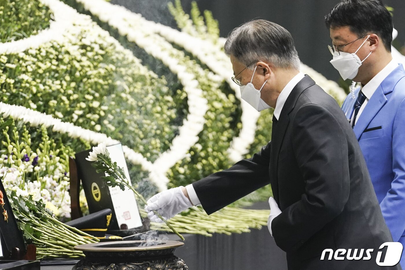 본문 이미지 - 문재인 대통령이 8일 오전 경기도 평택시 이충문화체육센터에서 엄수된 경기도 순직 소방공무원 합동영결식에서 헌화하고 있다. (청와대 제공)2022.1.8/뉴스1
