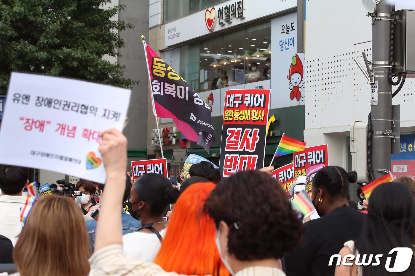 1일 오후 대구 중구 중앙로 대중교통전용지구 일대에서 열린 제14회 대구퀴어문화축제 참가자들이 도심을 행진하는 가운데 동성애를 반대하는 기독교 단체와 학부모 단체 등 시민들이 행진 구간 옆에서 피켓을 들어 보이고 있다. 2022.10.1/뉴스1 ⓒ News1 공정식 기자