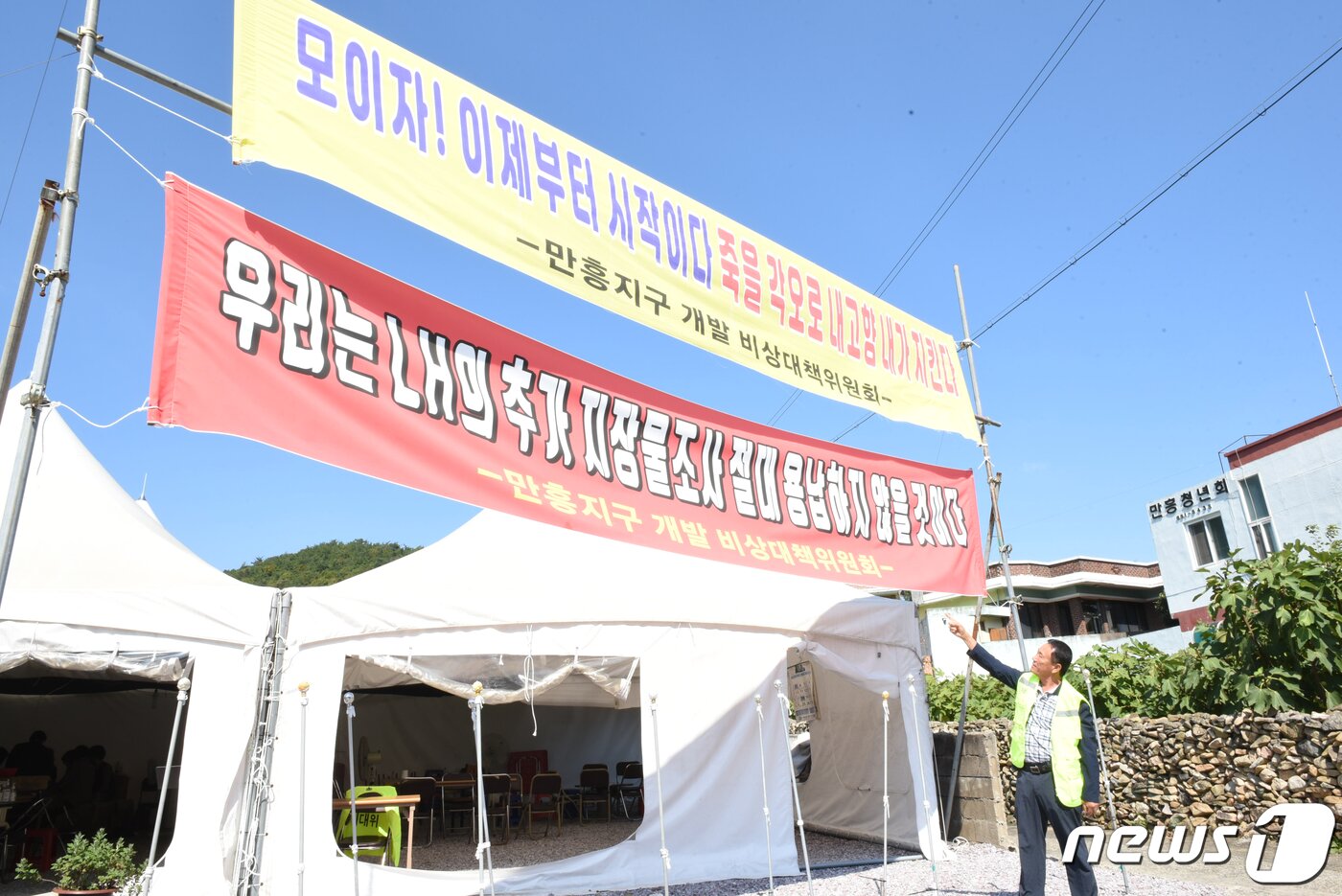 본문 이미지 - 전남 여수시 만성리 해수욕장 인근 마을 주민들은 지난 2019년 여수시와 한국토지주택공사(LH)가 추진하는 '공공지원민간임대주택 공급촉진지구 조성사업'을 반대하고 있다. 사진은 10월7일 김철수 만흥지구 비상대책위원장이 사업 반대 현수막을 가리키고 있다.2022.10.10/뉴스1 ⓒ News1 김동수 기자