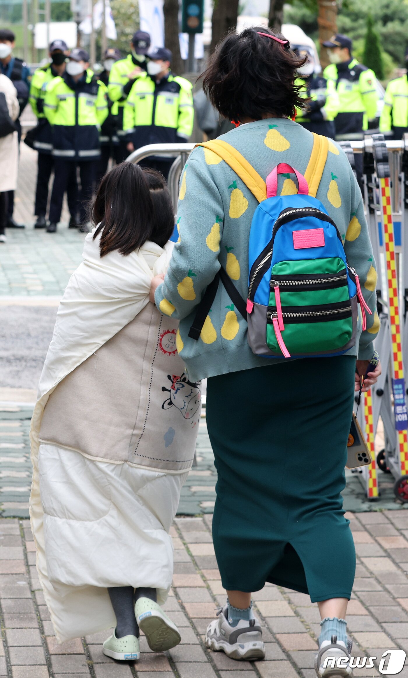 본문 이미지 - 전국의 아침 기온이 10도 밑으로 떨어지며 ‘가을 추위’가 성큼 다가온 10일 서울 용산구 삼각지역 인근에서 이불을 뒤집어 쓴 한 소녀가 엄마 손을 잡은 채 이동하고 있다. 2022.10.10/뉴스1 ⓒ News1 이동해 기자