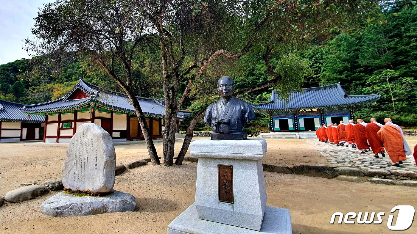 백담사 경내. 한용운 선생의 흉상 옆으로 스님들이 지나가고 있다. 옆의 시비 제목은 ‘나룻배와 행인’이다. 행인&#40;임&#41;을 기다리는 나룻배&#40;나&#41;의 마음을 읊었다.