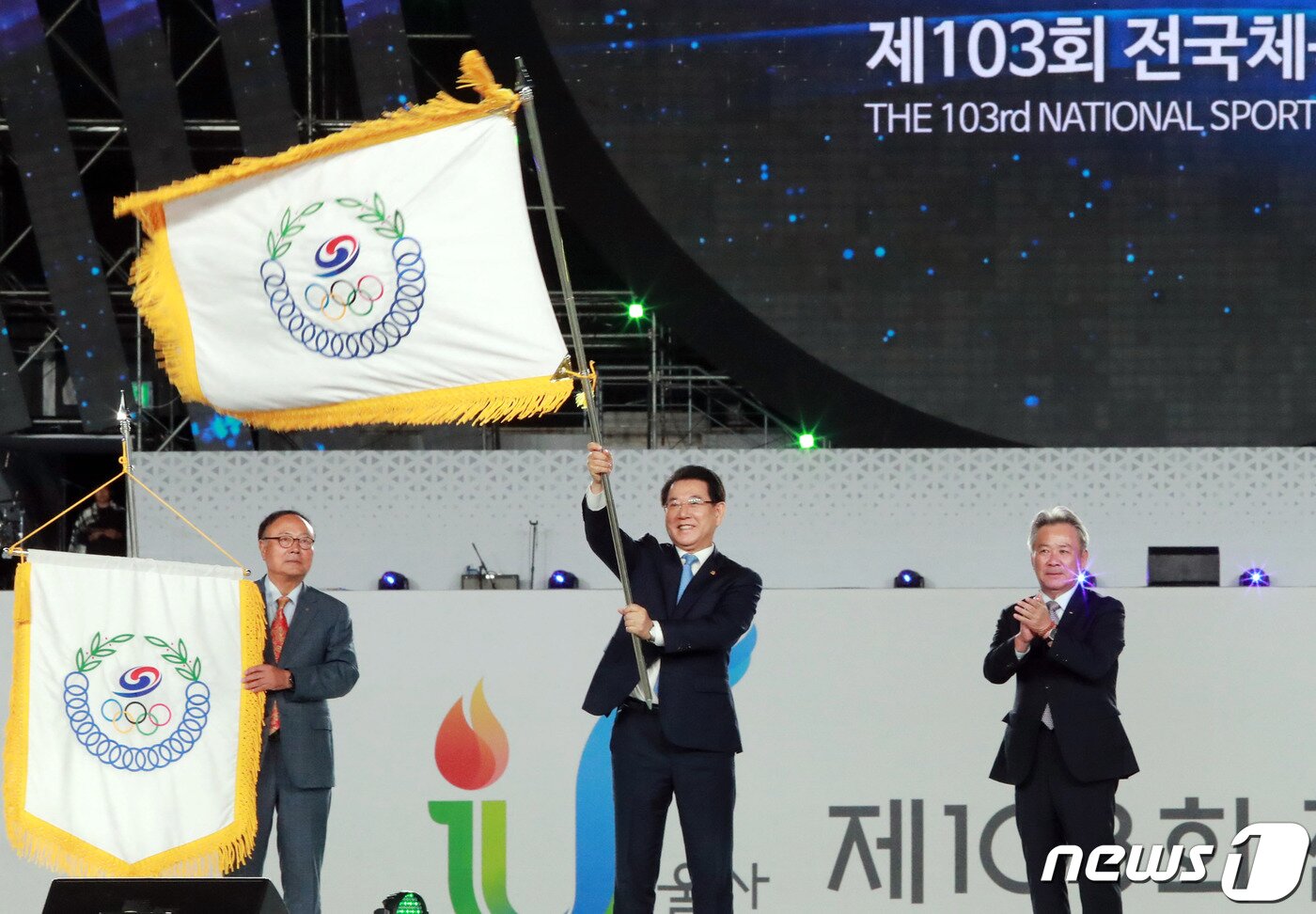 본문 이미지 - 김영록 전라남도지사가 13일 오후 울산종합운동장에서 열린 제103회 전국체육대회 폐회식에서 이기흥 대한체육회장으로부터 대회기를 전달 받은 뒤 힘차게 흔들고 있다. 전남도는 2023년 제104회 전국체육대회 개최도다.(전남도 제공) 2022.10.13/뉴스1 ⓒ News1 전원 기자
