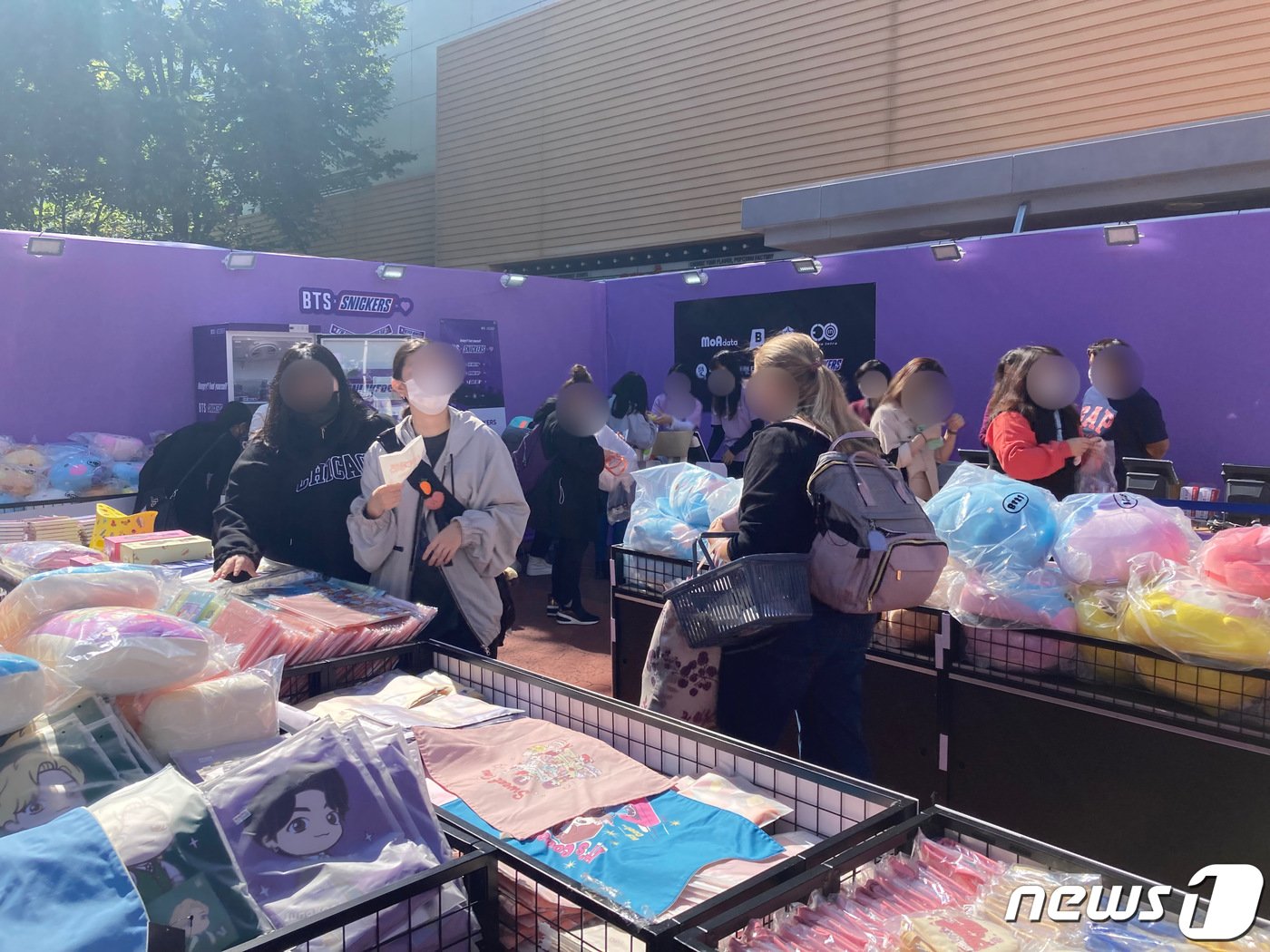 본문 이미지 - BTS 콘서트가 열리는 부산 연제구 아시아드주경기장 인근 대형마트 앞에 아미들이 BTS관련 물품을 보고 있다.2022.10.14/뉴스1 백창훈 기자 