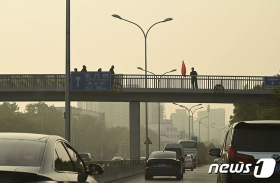 중국 공안요원들이 14일 지난 13일 시위가 벌어졌던 베이징 시통대교를 순찰하고 있다. © AFP=뉴스1 © News1 박형기 기자