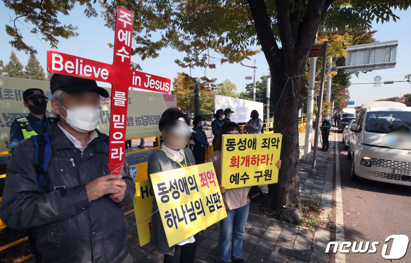 기독교 단체 관계자가 15일 인천시 남동구 구월동 중앙공원 월드컵 프라자에서 열린 퀴어축제장 앞에서 축제를 반대하는 홍보물을 들고 있다. 퀴어축제는 인천 지역에서 2018년 첫 개최됐으며, 이번 축제는 코로나19 후 3년만에 열렸다. 2022.10.15/뉴스1 ⓒ News1 정진욱 기자