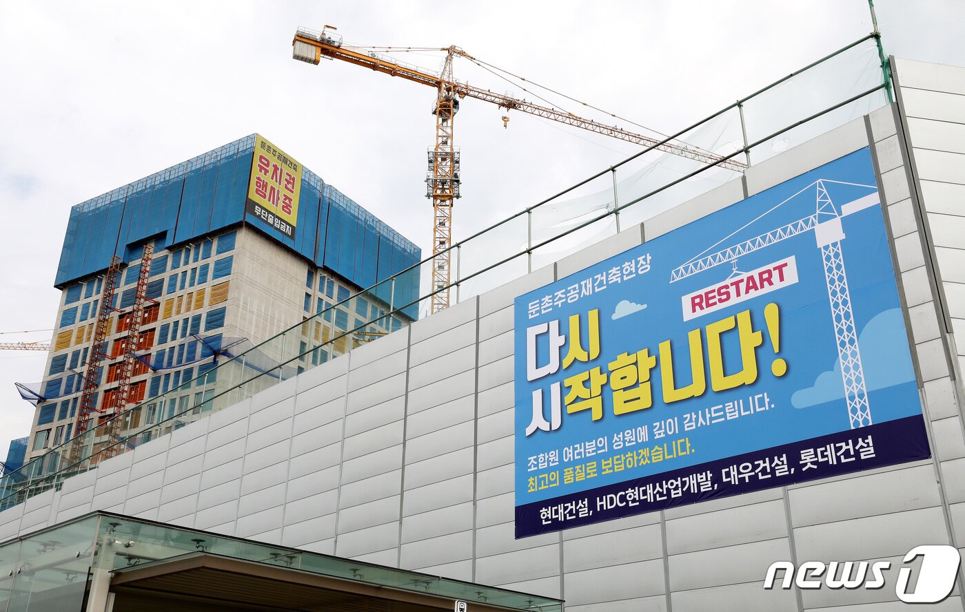 본문 이미지 - 16일 서울 강동구 둔촌주공 재건축 현장에 공사 재개를 알리는 현수막이 붙어 있다. 6개월간 멈춰섰던 둔촌주공아파트 재건축 사업이 오는 17일부터 다시 시작된다. 2022.10.16/뉴스1 ⓒ News1 박지혜 기자