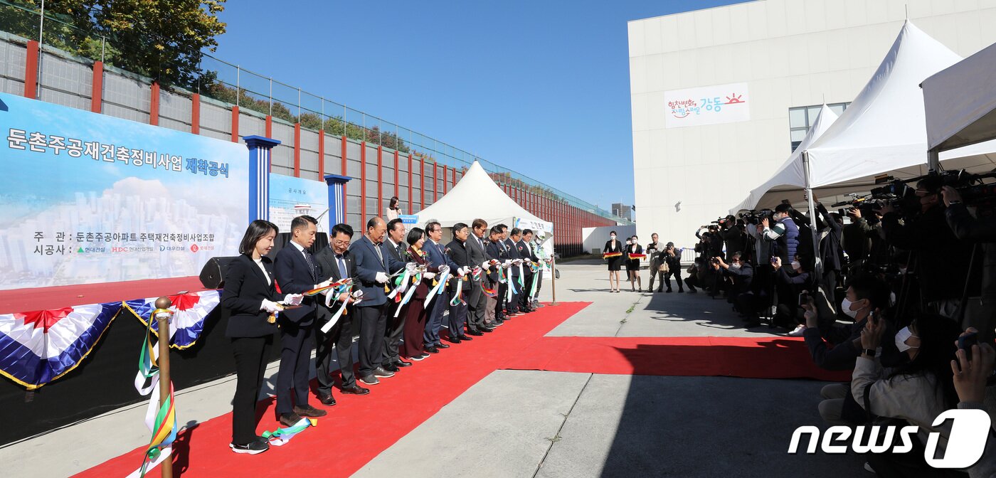 본문 이미지 - 17일 오전 서울 강동구 둔촌주공 견본주택에서 열린 재건축 재착공식에서 참석자들이 테이프를 자르고 있다. 이날 공사비 증액 갈등으로 공사가 중단됐던 서울 강동구 둔촌주공 아파트 재건축(새 단지명 '올림픽파크포레온') 사업이 약 6개월 만에 재개됐다. 2022.10.17/뉴스1 ⓒ News1 박지혜 기자