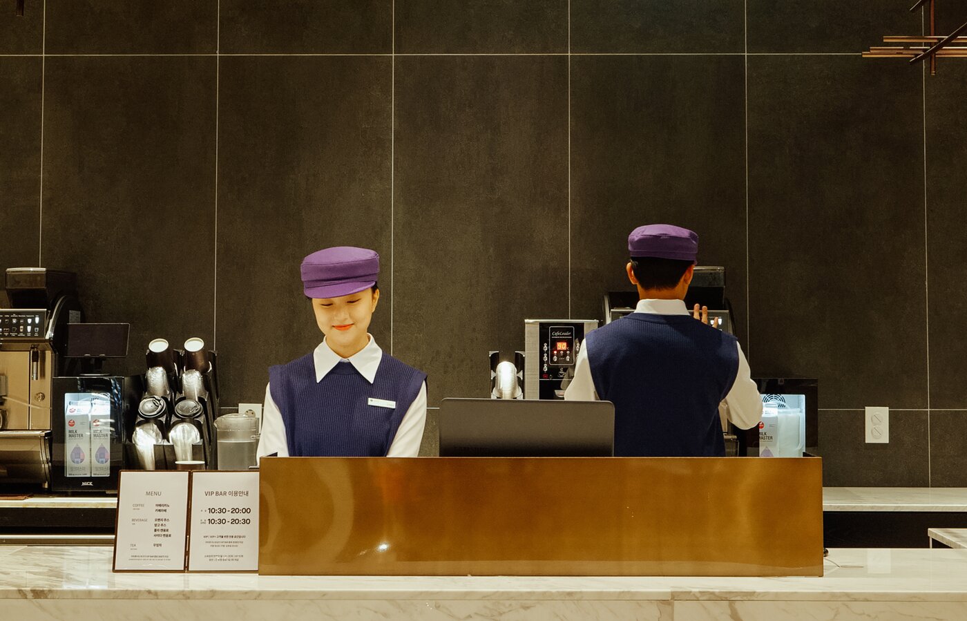 본문 이미지 - VIP 바에서 직원이들이 새로운 유니폼을 입고 근무를 하는 모습(롯데백화점 제공)