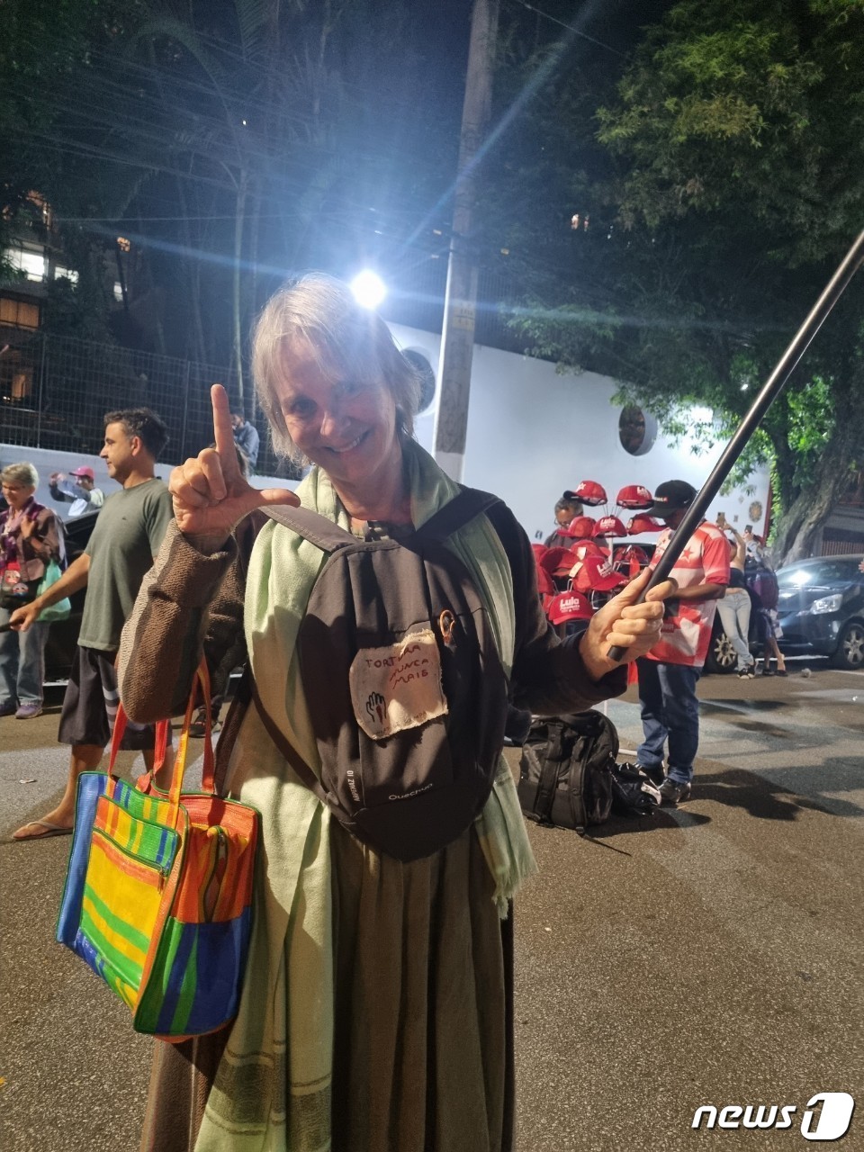 (상파울루=뉴스1) 최서윤 기자 = 24일(현지시간) 루이스 이나시우 룰라 다 실바 전 브라질 대통령 연설 행사가 이뤄진 상파울루 가톨릭대 극장 밖에서 한 지지자가 엄지와 검지 손 …