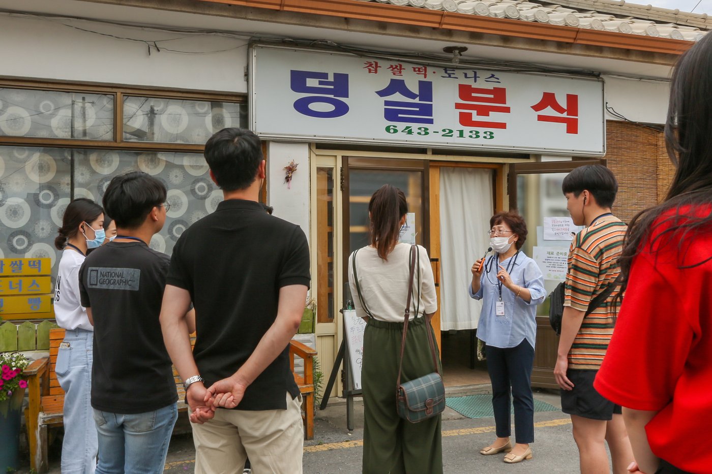 덩실분식 앞에서 해설사가 덩실분식에 대해 설명하고 있다&#40;한국관광공사 제공&#41;