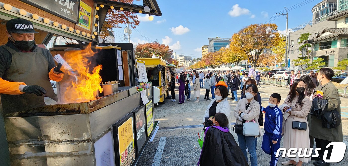 29일 구미시청앞 복개천에서 열린 &#39;제1회 구미푸드·핼러윈 페스티벌&#39; 에 참여한 시민들이 불쇼가 펼쳐지는 푸드트럭앞에서 줄을 서있다. 구미시는구미 음식의 맛과 멋을 알리고 건강하고 안전한 푸드 축제로 코로나로 지친 시민을 위로하기 위해서 축제를 기획했다. 2022.10.29/뉴스1 ⓒ News1 정우용 기자