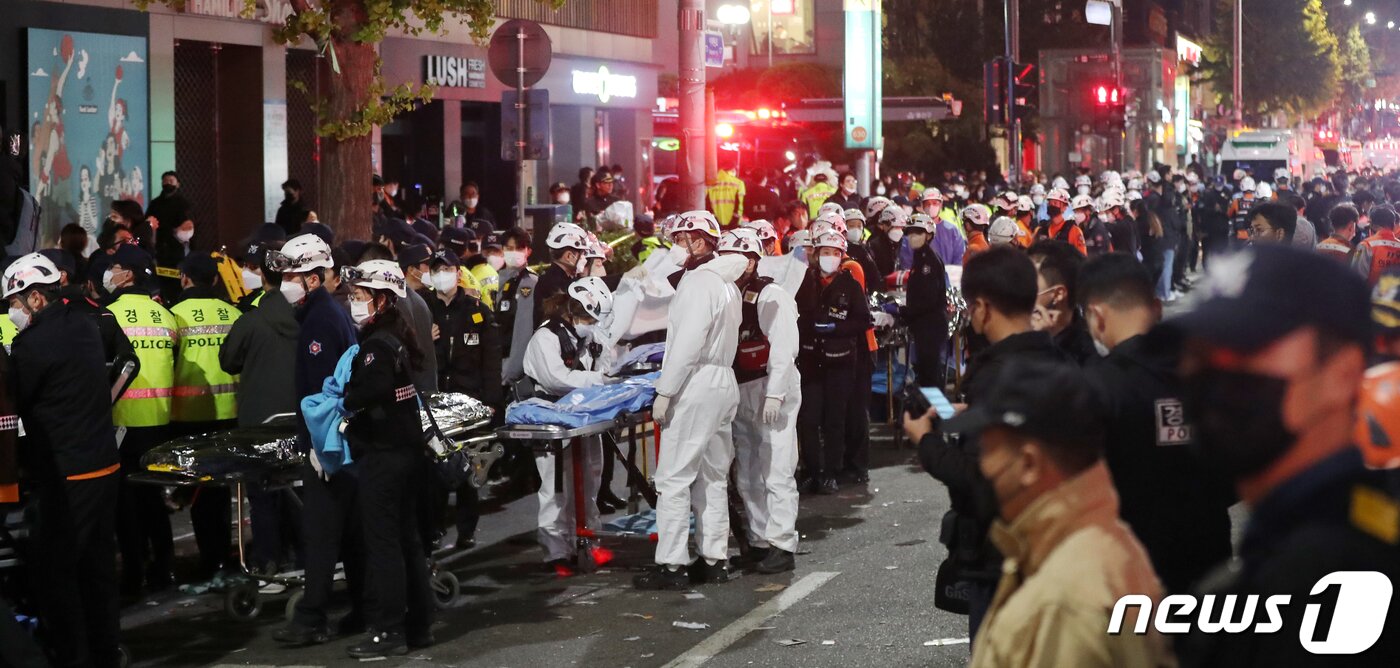 본문 이미지 - 30일 새벽 서울 용산구 이태원 일대에서 의료진과 소방대원들이 압사 사고 사망자들을 이송하기 위해 길게 줄을 서 대기하고 있다. 소방당국은 이번 사고로 현재까지 120명이 숨지고 100명이 부상했다고 밝혔다. 2022.10.30/뉴스1 ⓒ News1 민경석 기자